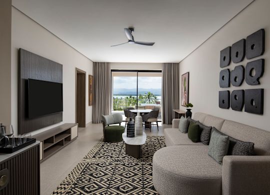 Espace salon avec téléviseur, coin détente confortable et tables