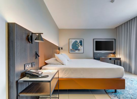 pokój z łóżkiem i telewizorem