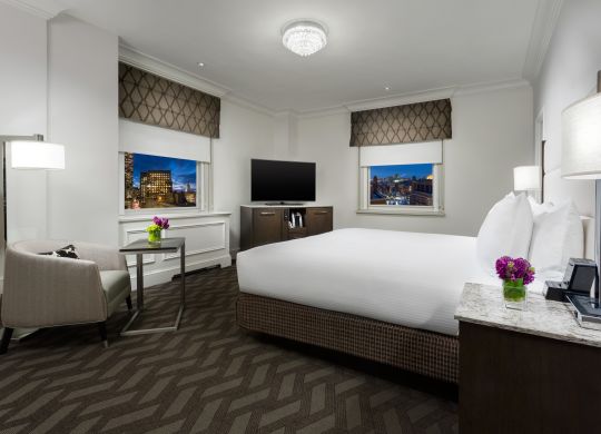Bed in room with chair and TV