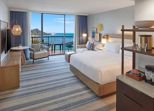 Large Bed, Sofa and Sitting Area in a Guest Room with Balcony and Water View