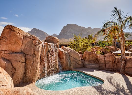 Cold Plunge Pool with a Cascade, Palm Tree and Mountains in Background
