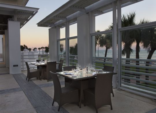 Gün Batımında Masalar ve Sandalyeler Bulunan Açık Teras Oturma Alanı