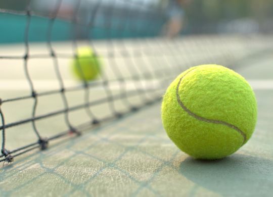 Detail tenisového míčku po síti