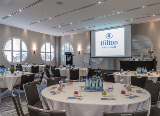 Meeting Room Set up with Round Tables and a Projection Screen