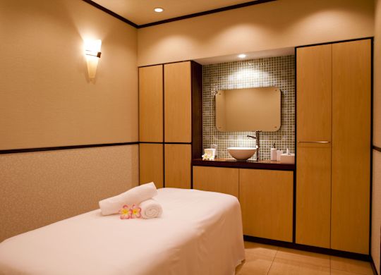 ซาลอนผ่อนคลายพร้อมดอกไม้และผ้าเช็ดตัวบนโต๊ะนวดและอ่างล้างมือ