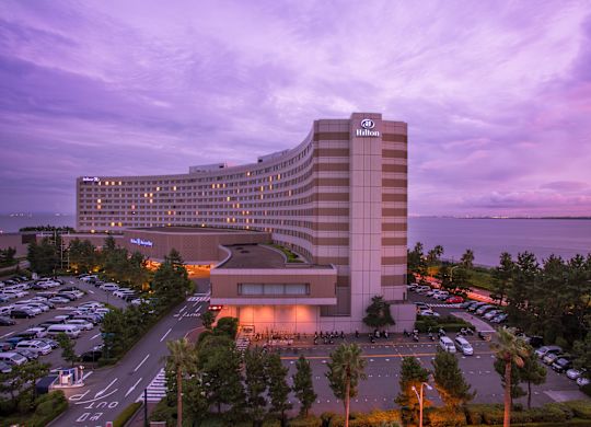 ไฟส่องสว่างภายนอกโรงแรม ป้าย และรถยนต์สำหรับแขกบนลานจอดรถที่ Dusk