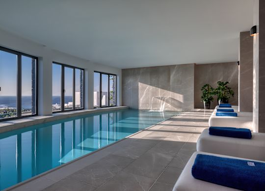 Swimmingpool im Spa mit Liegestühlen und Wasserfall.