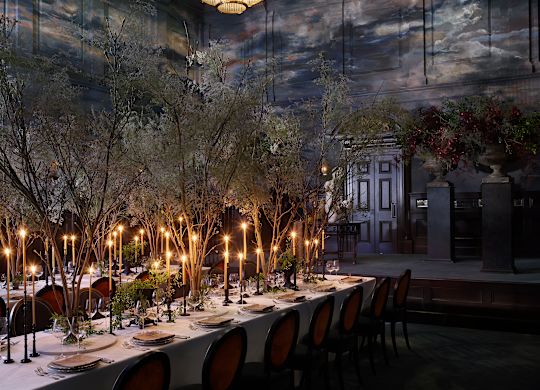 Magistrates' ballroom, candlelit event set up with a long table and stormy sky mural on walls and ceiling.