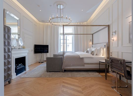 Quarto com cama, mesa de trabalho, área de estar e TV