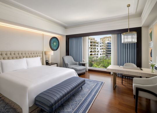 Habitación con cama King, escritorio, sillón y ventana amplia