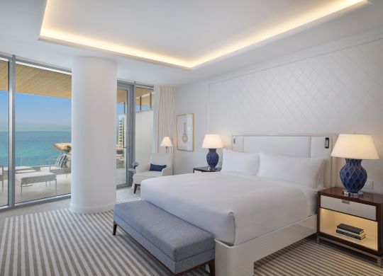 King bedroom with nightstands and balcony access
