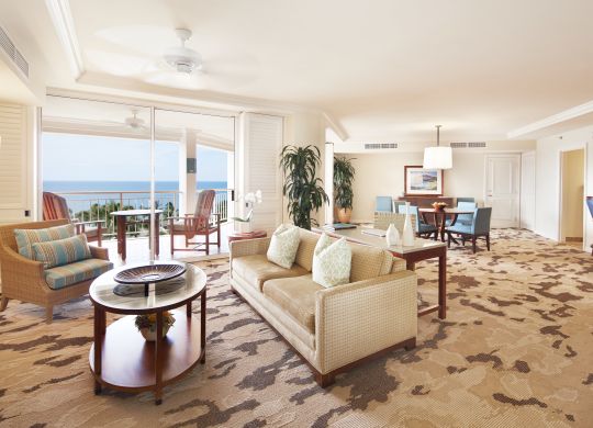 Wailea Suite living area with bar seating, dining table with seating for four, and large balcony patio overlooking the ocean