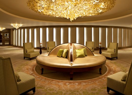 Lounge Area with Circular Settee, Satin Pillows, Chandeliers, and Recessed Lighting