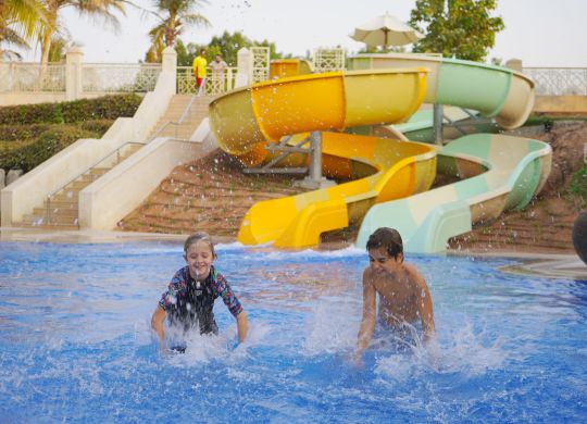 Kids playing on a pool with water slides