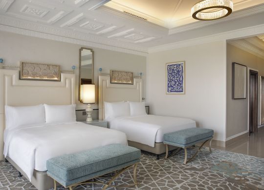 Two beds in room with art on wall