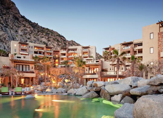 Fotografía de la fachada del hotel Waldorf Astoria Los Cabos Pedregal con piscina en primer plano.