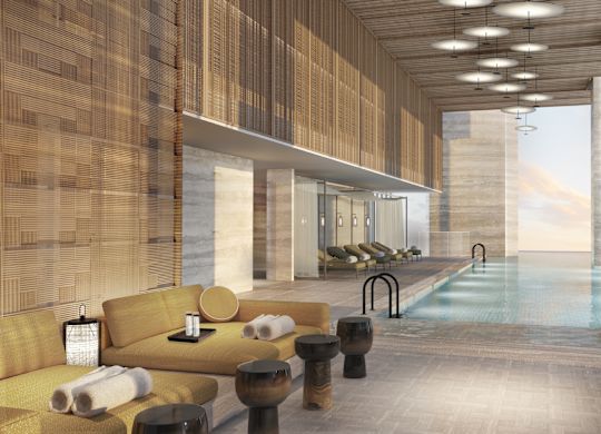 Hotel Wewnętrzna strefa basenu z leżakami i strefami wypoczynkowymi