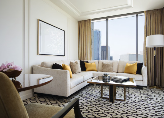 Wilshire Suite living area with large sectional sofa and view of the city