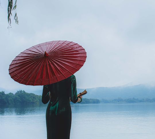 Una donna che si gode la vista del lago occidentale di Hangzhou, Cina