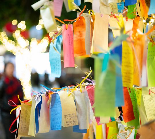 Desejos escritos em Tanzaku, pequenos pedaços de papel, e pendurados em uma árvore de desejos, localizada na seção Little Tokyo de Los Angeles, Califórnia, fotografada em um shopping ao ar livre à noite.