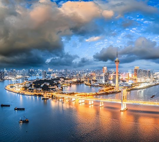 黃昏天際,俯瞰港口,擁有燈光明亮的橋樑、高樓和閃閃發光的城市景觀。