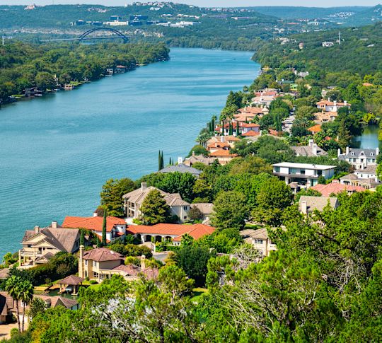 Panorama shot of Colorado River flowing through Austin with residential houses and boats