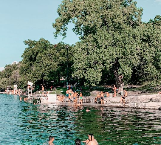 People swimming in Barton Springs Pool, a natural spring-fed swimming pool located within Zilker Park in Austin, Texas