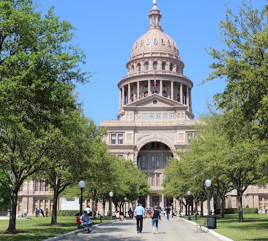 People walking in the park at the Texas State Capitol in Austin, Texas.