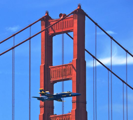 An Airplane Flying Across the Golden Gate Bridge