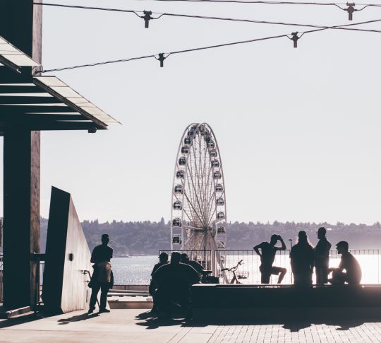 People standing around in front of Wheel of Seattle