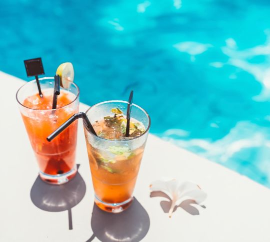 Deux cocktails dans de grands verres au bord de la piscine