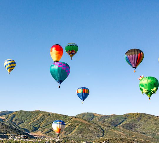 People Riding on Hot Air Balloons in a Mountainous Area