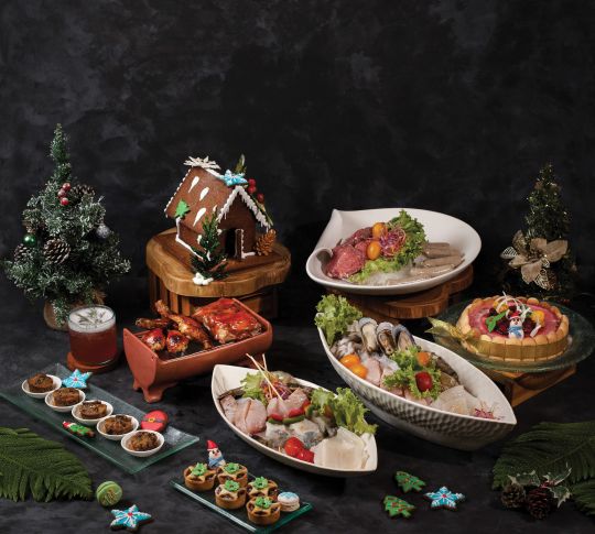 A Christmas display of various seafoods, meats and desserts.