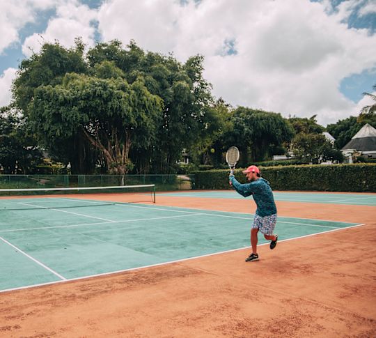 A person playing tennis at the resort
