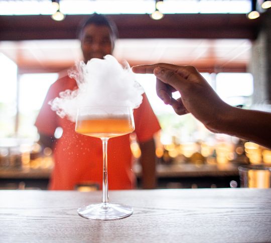 Person, die in der Bar "Sega" einen Drink mit Rauch serviert