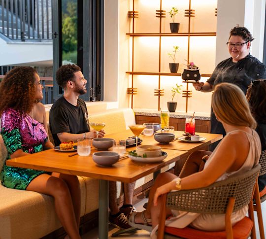 El camarero lleva comida a la gente que come en Tiger Bite