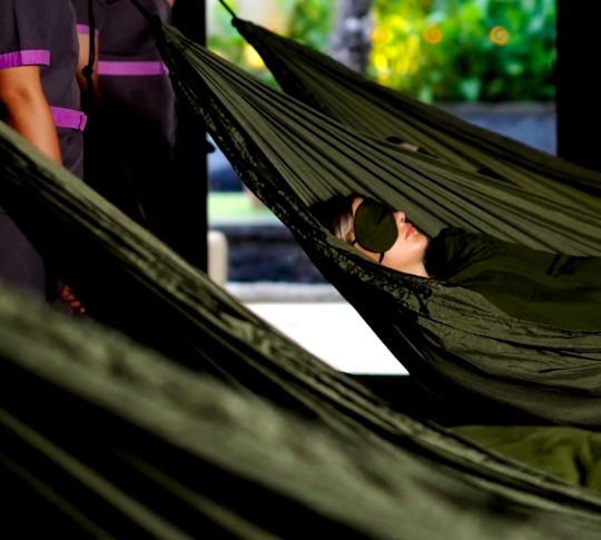 A person enjoying cocoon sway therapy at the spa