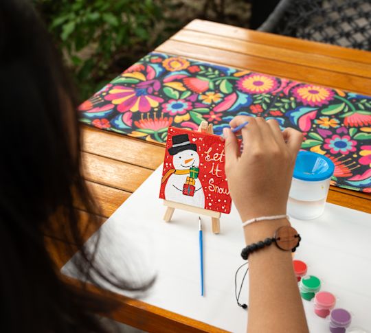 Frau malt von Hand eine Weihnachtskarte 