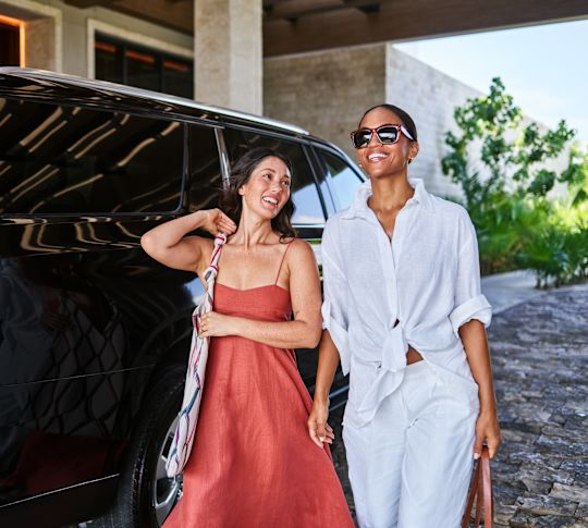 Zwei lächelnde Frauen bei Ankunft im Hotel