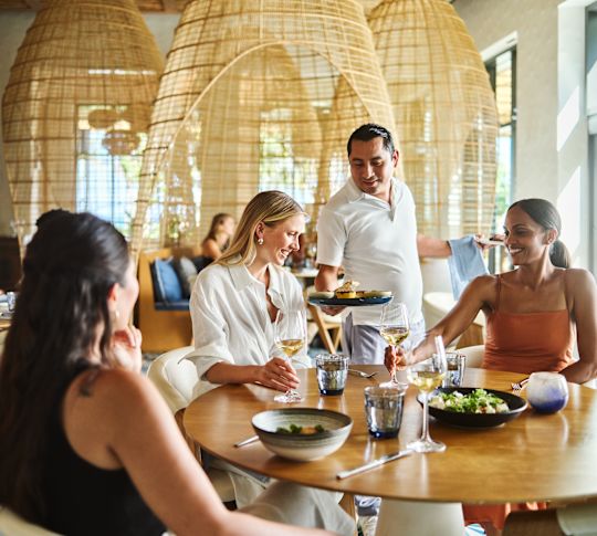 Skupina lidí v restauraci Maratea. Zaměstnanec servírující jídlo
