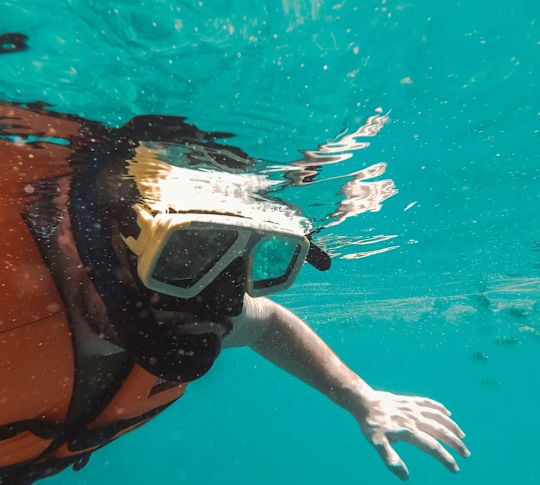Persoană care face snorkeling sub apă