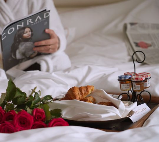 Woman Having Breakfast in Bed at a Hotel