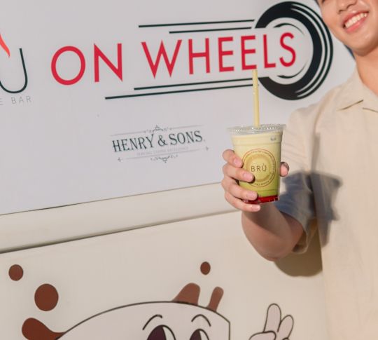Uomo che tiene una tazza di caffè al Bru On Wheels