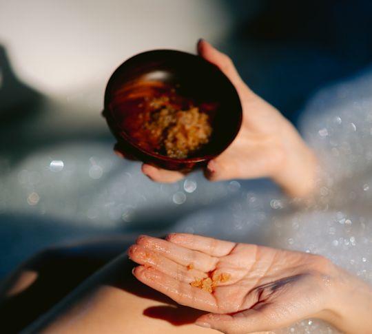 Kobieta trzymająca produkt leczniczy w wannie w spa