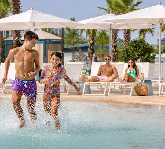 niños nadando en la piscina al aire libre, huéspedes descansando junto a la piscina