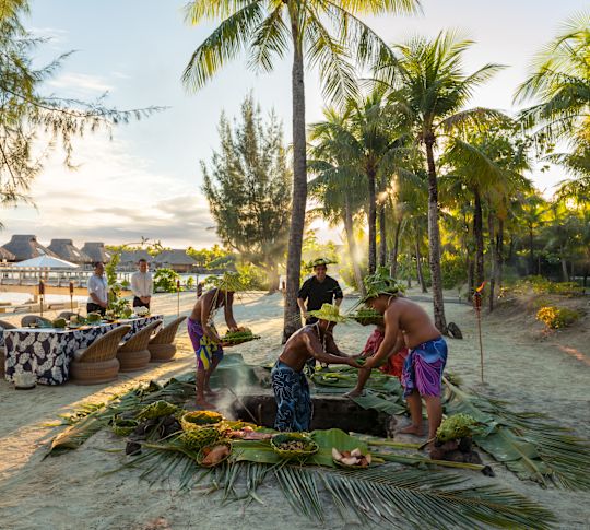 Mannen bereiden Polynesische barbecue voor