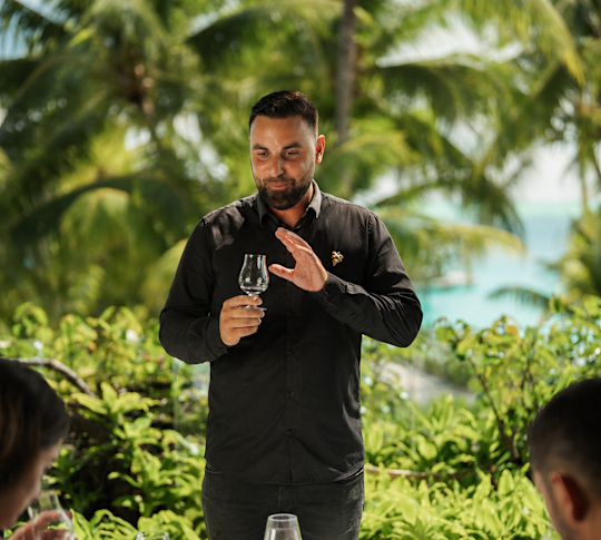 A Sommelier Presenting Wine to a Couple for Tasting