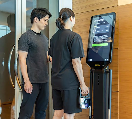 En kvinna med en tränare på ett fitnesscenter