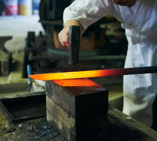 Man Forging Metal into a Sword