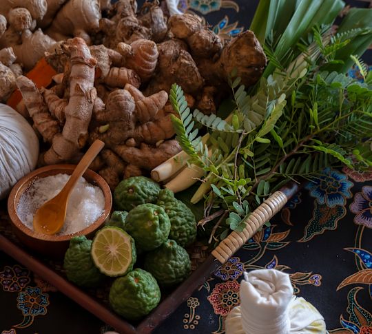 Frau, die Kräuterpackungen herstellt, die sie bei Massagesitzungen verwenden kann.